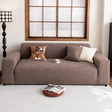 Mocha brown corduroy stretch sofa cover in a cozy room with terracotta and cream cushions