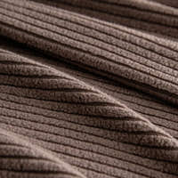 Macro of mocha brown corduroy fabric showing its deep vertical ribbing