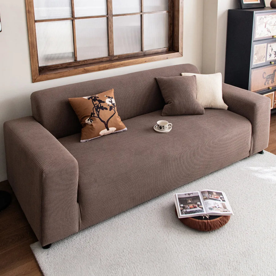 Mocha brown corduroy sofa cover styled in a warm living room with layered cushions