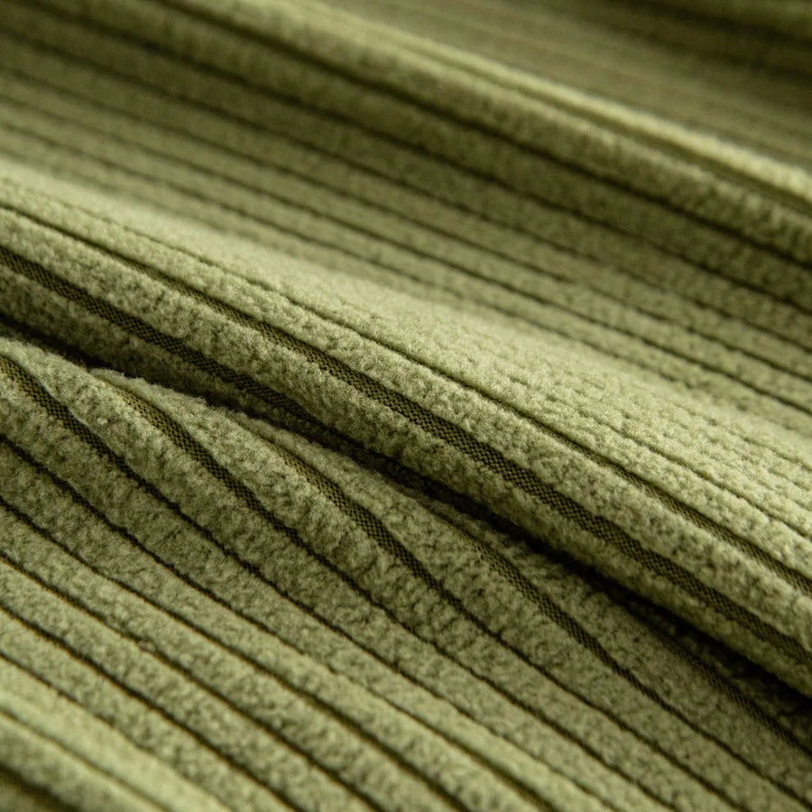 Macro of olive green corduroy fabric revealing its plush vertical ribbed weave