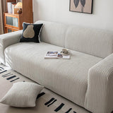 Silver Cloud corduroy sofa cover styled with a black accent cushion and an open magazine
