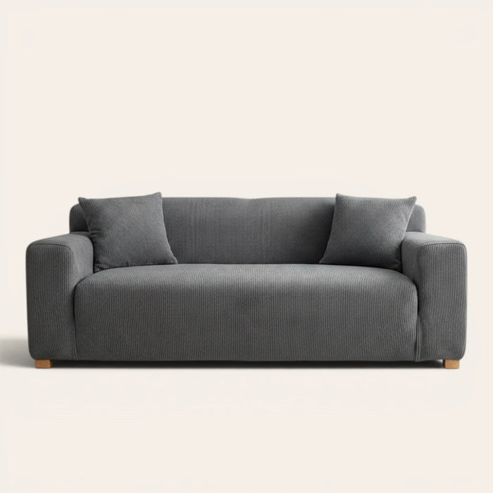 Steel Gray corduroy sofa cover fitted on a three-seat sofa with matching cushions, front view on ivory