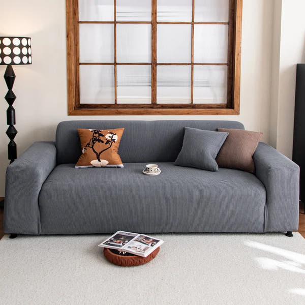 Steel Gray corduroy sofa cover in a living room with a wood-framed window and floor lamp