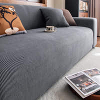 Angled view of the Steel Gray corduroy sofa cover styled with cushions and a coffee cup