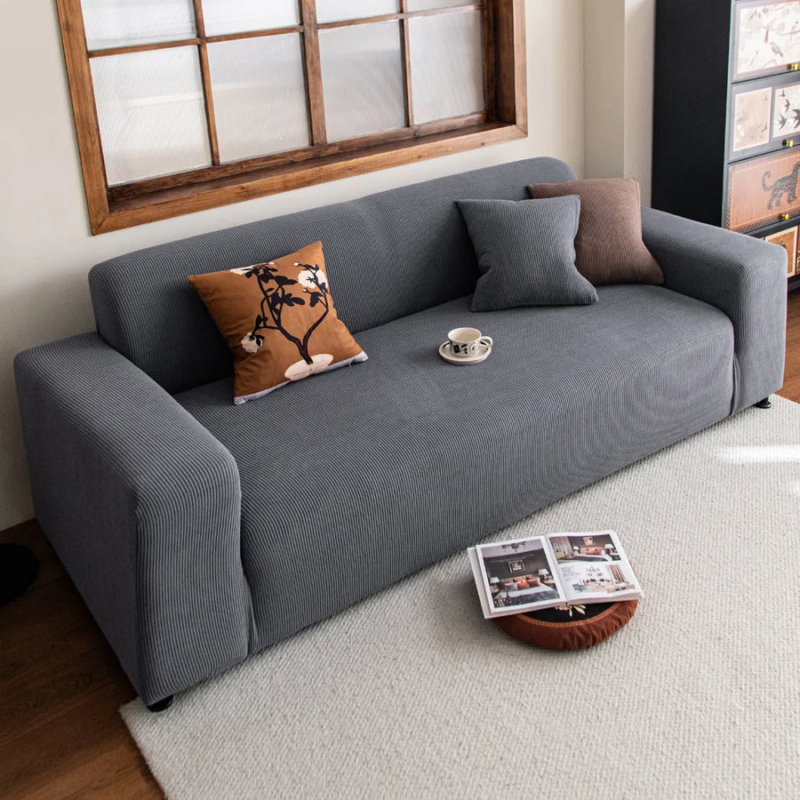 Steel Gray corduroy sofa cover in a cozy living room with botanical and brown accent cushions