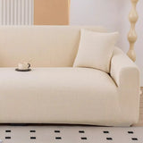 Warm beige corduroy stretch sofa cover in a bright room with a cushion and coffee cup