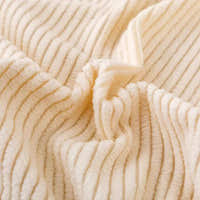 Macro of warm beige corduroy fabric showing its soft raised vertical ribbing