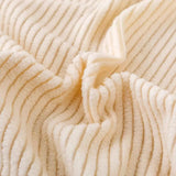 Macro of warm beige corduroy fabric showing its soft raised vertical ribbing