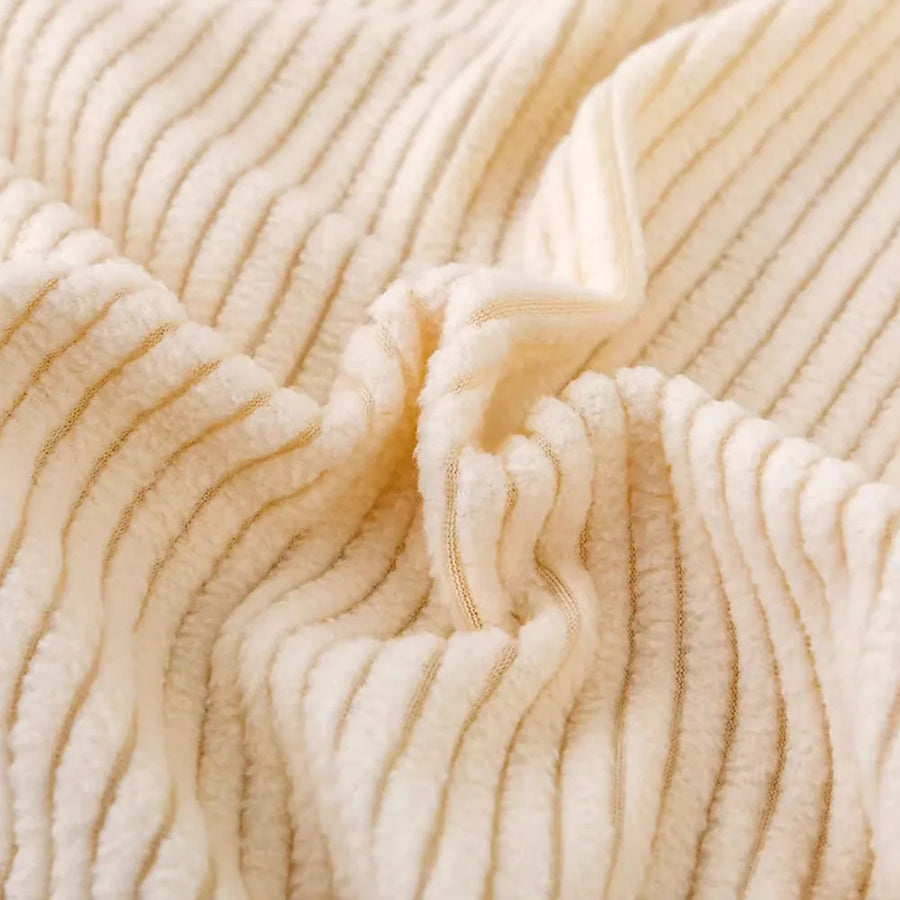 Macro of warm beige corduroy fabric showing its soft raised vertical ribbing