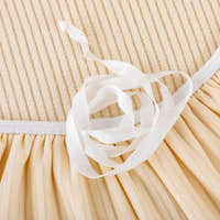 Detail of the white drawstring tie tucking the warm beige corduroy cover under the seat