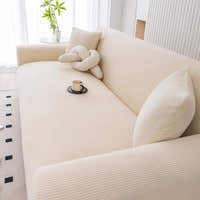 Angled view of warm beige corduroy sofa cover with a knot cushion and coffee cup