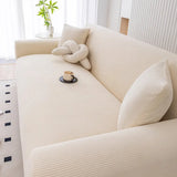 Angled view of warm beige corduroy sofa cover with a knot cushion and coffee cup