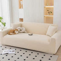 Warm beige corduroy sofa cover in an airy living room with a cat and knot cushion
