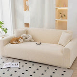 Warm beige corduroy sofa cover in an airy living room with a cat and knot cushion