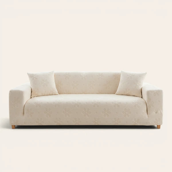Cream Petal floral sofa cover fitted on a three-seat sofa with matching cushions, front view on ivory