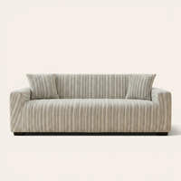 Arrow Gray geometric sofa cover fitted on a three-seat sofa with matching cushions, front view on ivory