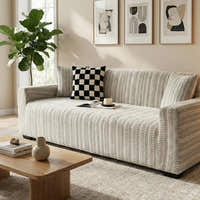 Arrow Gray geometric sofa cover in a bright room with a checkerboard cushion, angled view