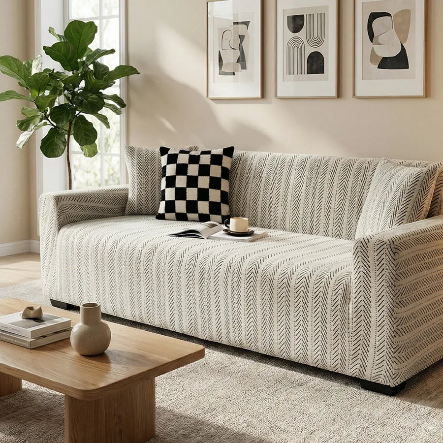 Arrow Gray geometric sofa cover in a bright room with a checkerboard cushion, angled view