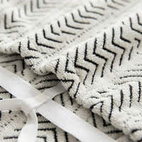 Macro close-up of the Arrow Gray woven fabric showing its chevron geometric pattern and elastic strap