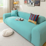 Aqua Mist ice silk sofa cover styled with a striped accent cushion, angled living room view