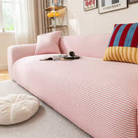 Angled view of the Blush Petal ice silk sofa cover hugging the seat near a sunlit window