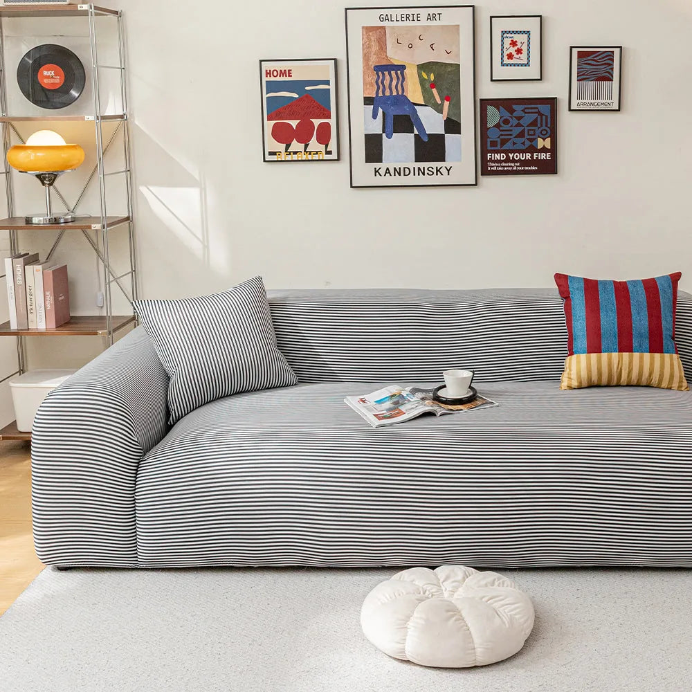 Midnight Tide ice silk sofa cover in a gallery-wall living room with books and a coffee cup
