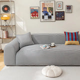 Midnight Tide ice silk sofa cover in a gallery-wall living room with books and a coffee cup
