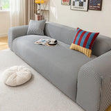 Midnight Tide ice silk sofa cover styled with a striped accent cushion, angled living room view