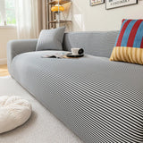 Close angled view of the Midnight Tide ice silk cover draping snugly over a sofa by a window