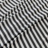 Macro close-up of the Midnight Tide ice silk fabric showing its crisp black and white stripe