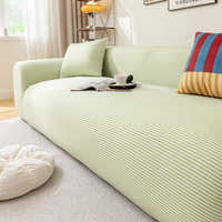 Angled view of the Mint Breeze ice silk sofa cover draping a sofa near a sunlit window