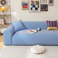 Blue striped ice silk sofa cover in a bright room with a gallery wall, an open magazine and a coffee cup