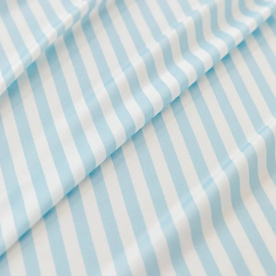 Macro of the ice silk weave with fine light blue and white stripes, showing its smooth cool sheen