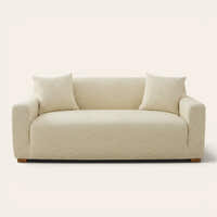 Cream beige jacquard sofa cover on a three-seater, front view on ivory backdrop with two matching cushions