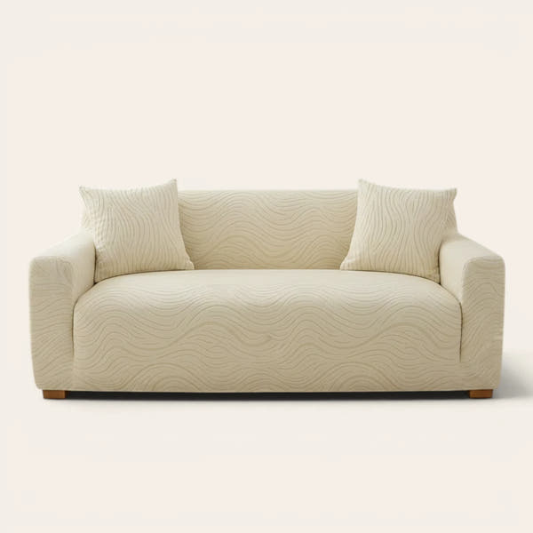 Cream beige jacquard sofa cover on a three-seater, front view on ivory backdrop with two matching cushions
