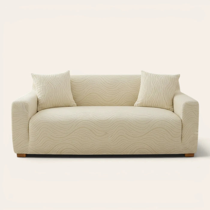 Cream beige jacquard sofa cover on a three-seater, front view on ivory backdrop with two matching cushions