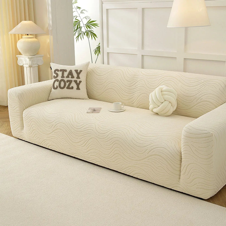 Angled view of the cream beige jacquard sofa cover, wavy texture styled with a teacup and cushions