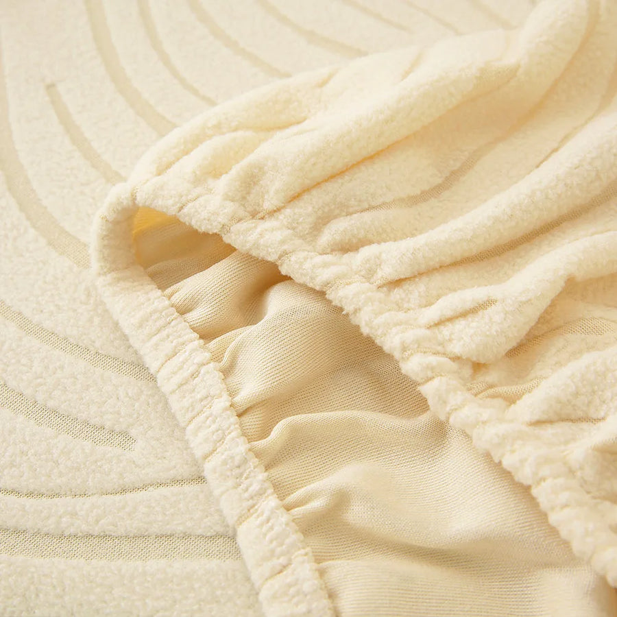 Close-up of the stretchy elasticated hem gripping the underside of the cream beige jacquard cover