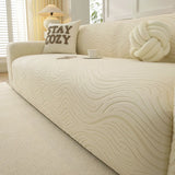 Cream beige jacquard sofa cover in a sunlit room with a table lamp, cozy cushion and teacup