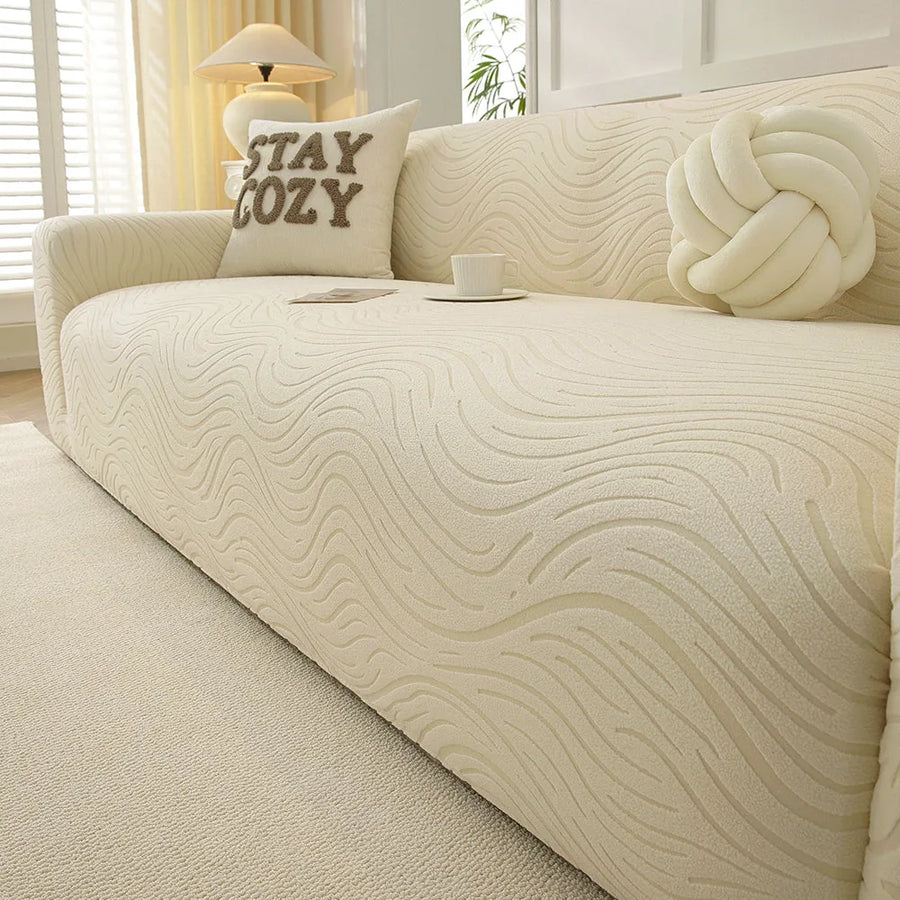 Cream beige jacquard sofa cover in a sunlit room with a table lamp, cozy cushion and teacup