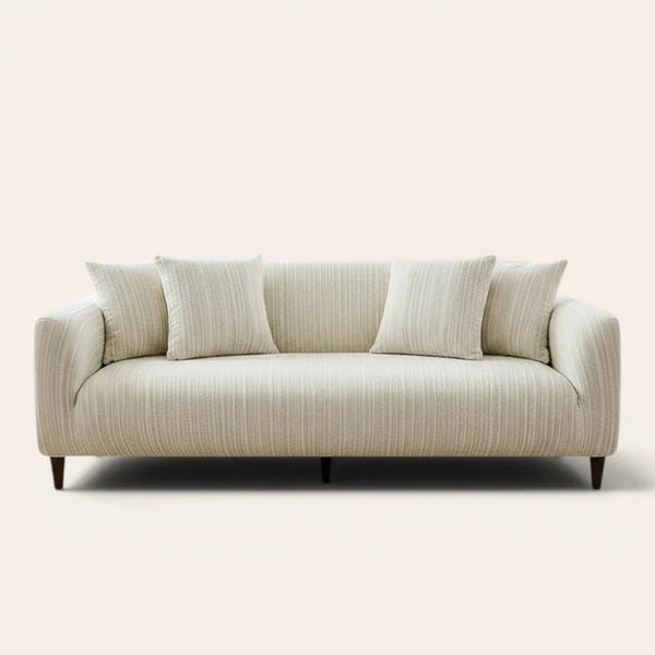 Cream ivory jacquard sofa cover on a three-seater, front view on ivory backdrop with matching cushions