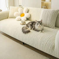 Cream ivory jacquard sofa cover on a large sofa with a cat lounging, a flower cushion and teacup in a bright room