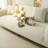 Cream ivory jacquard sofa cover on a large sofa with a cat lounging, a flower cushion and teacup in a bright room