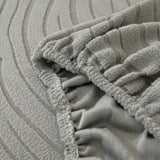 Close-up of the stretchy elasticated hem gripping the underside of the mist grey jacquard cover