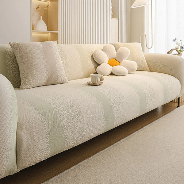 Cream and sage striped jacquard sofa cover styled in a bright room with a flower cushion and coffee cup