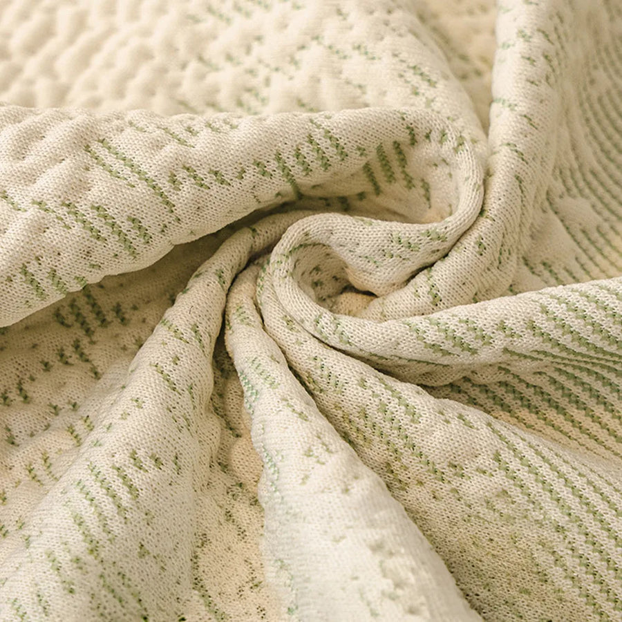 Macro of the cream jacquard weave flecked with sage green, showing its knit-like textured stripes