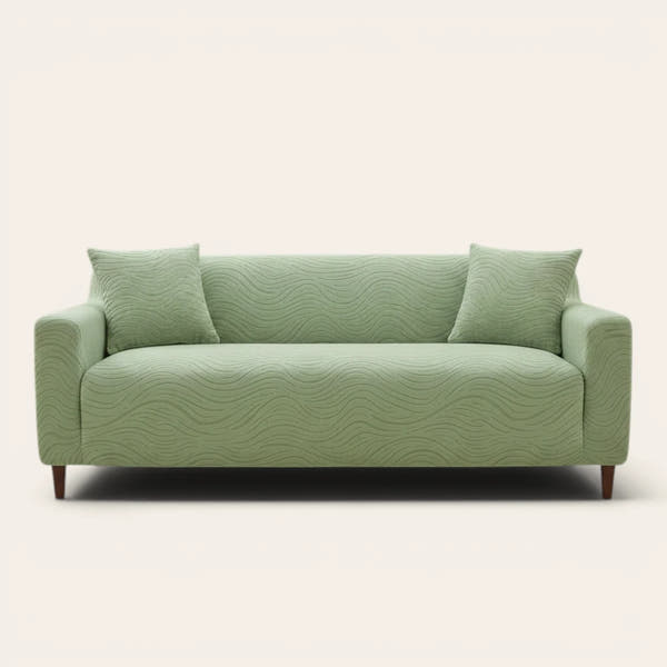 Sage green jacquard sofa cover on a three-seater, front view on ivory backdrop with two matching cushions