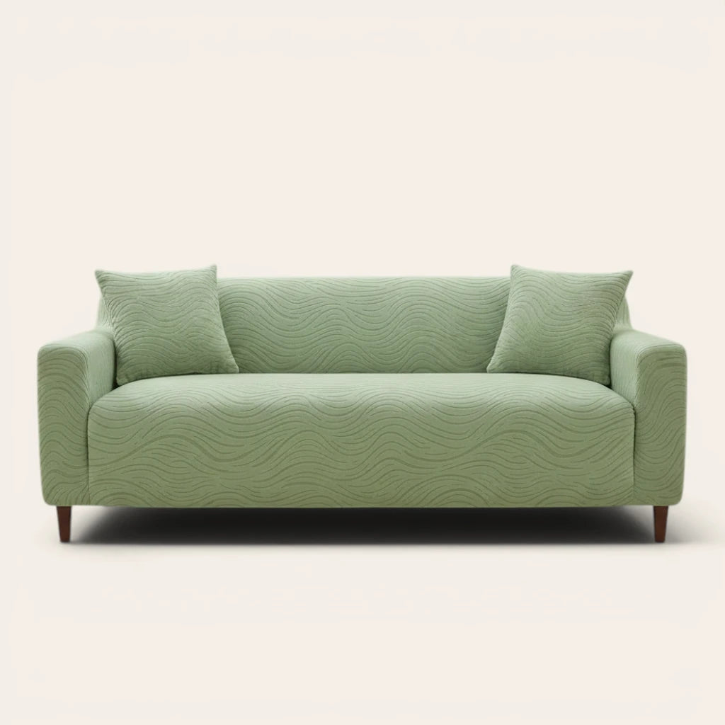 Sage green jacquard sofa cover on a three-seater, front view on ivory backdrop with two matching cushions