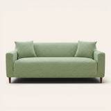 Sage green jacquard sofa cover on a three-seater, front view on ivory backdrop with two matching cushions