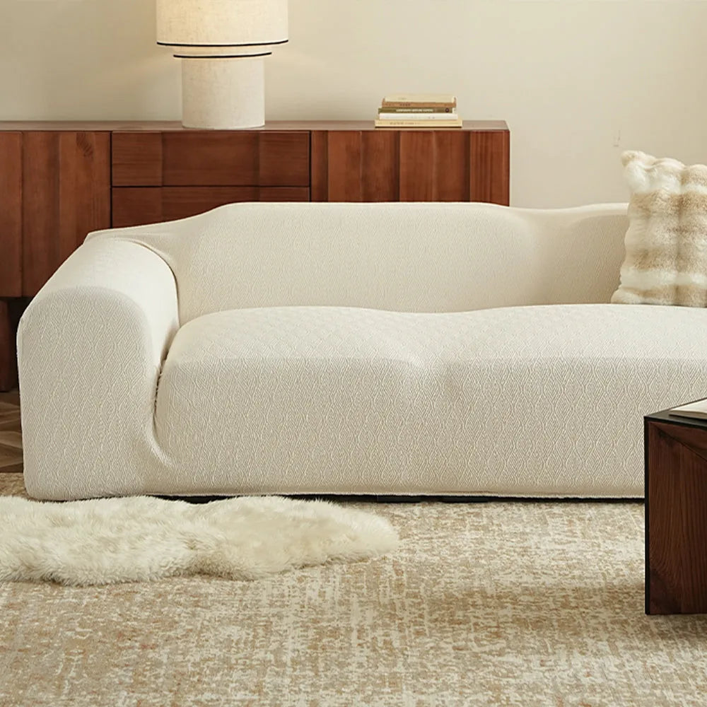 Sand linen jacquard sofa cover styled in a bright living room with a wood sideboard and sheepskin rug